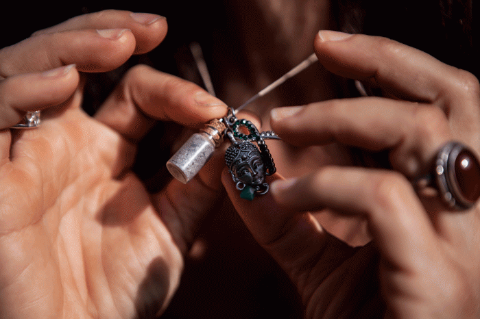 Yolie Moreno holds up her necklace with a vial of sacred soil made out of incinerated letters, gifts and other mail sent by people around the world after the Sandy Hook Elementary school shooting. Before the items were incinerated, Moreno helped digitally document and compile them. The sacred soil will potentially be made into bricks and used to make a memorial.   Morgan Spiehs 